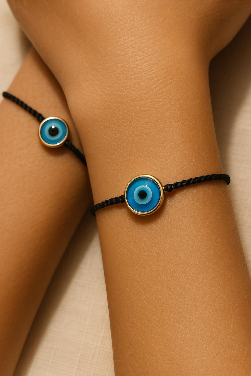 FOUTNI Black Edition braided cord bracelet with a gold-rimmed evil eye charm on a wrist
