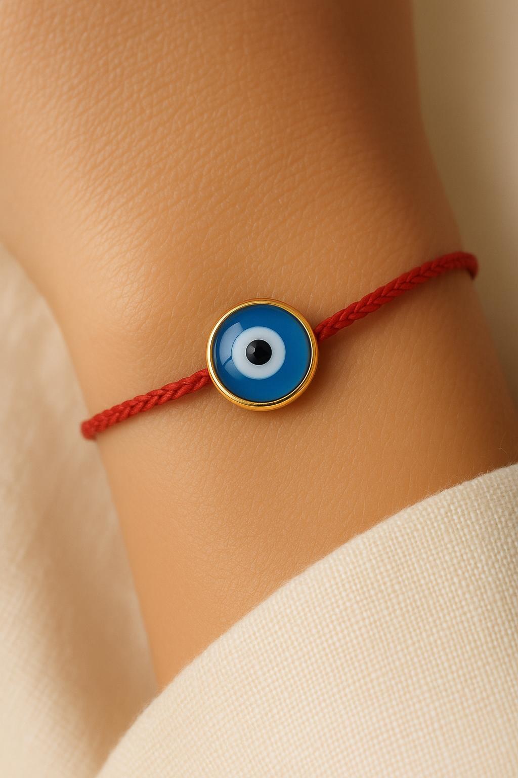 FOUTNI Red Edition braided cord bracelet with a gold-rimmed evil eye charm on a wrist
